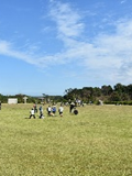 青空と芝生で遊ぶ子どもたちの写真