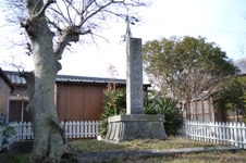 白色の低い柵で囲まれた奥に立つ斎王尾野湊御禊場跡の石碑の写真