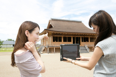 2名の女性が正殿に向けてタブレットをかざしてVR映像を見ている写真