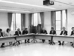 L字型に設置された長机の席につき話し合いをしている委員の写真