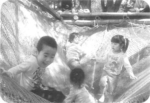 ネットが張られた遊具で遊んでいる子供たちの写真