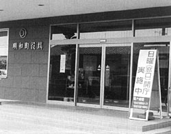 「日曜(窓口)開庁実施中」と書かれた看板がたてられている役場入口の写真