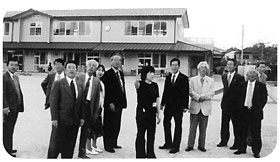 栗東市の担当者が指さす方向を見ている視察委員の写真