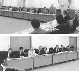 上:席についている委員のうちの一人が席を立って発言している写真、下:席について話し合いをしている委員の写真