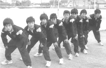 膝に手を当てて前かがみになって一列に並んでいるジャージ姿の男子学生の写真