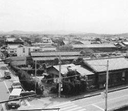 横断歩道のある交差点と住宅が立ち並ぶ街並みの写真