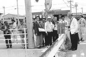横断歩道のある交差点に立って道路状況を視察している総務産業常任委員の写真