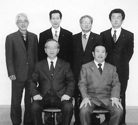 2名が椅子に座り、その後ろに4名が立っている委員の集合写真