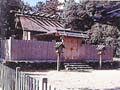 石が積まれた土台の上に一枚ずつ板で囲まれた竹神社の拝殿の写真