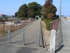 左右を柵で囲った細長い通りの奥に樹木で囲まれた隆子女王の墓の写真