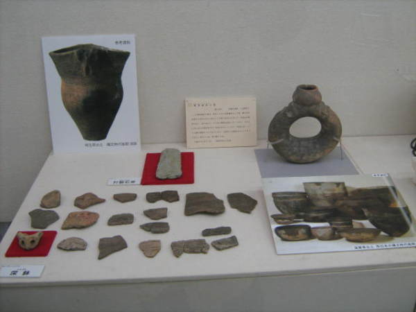 土器の写真パネルや深鉢の欠片、ドーナツ型の土器が展示されている写真