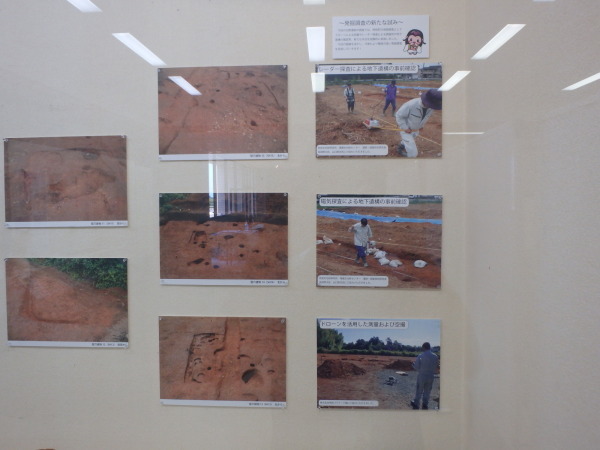 壁に発掘調査の作業の様子や発掘場所の写真が展示されている写真
