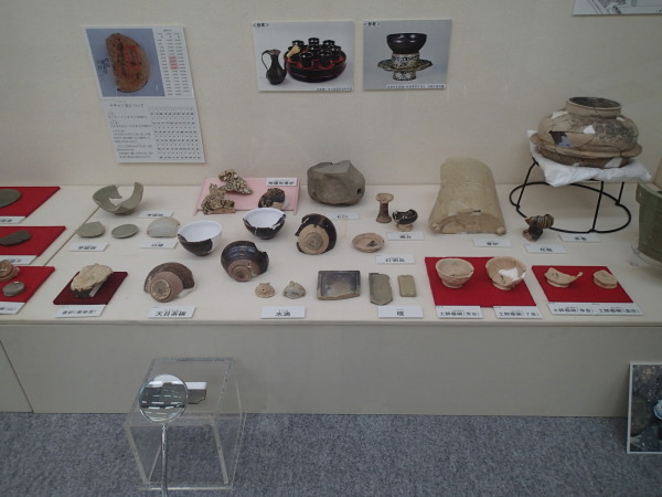 右側に大きな土鍋、手前に土器や天目茶碗などの遺跡が展示されている写真