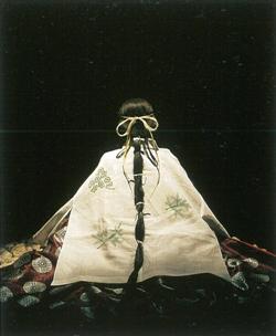 長い髪の毛を結び着物を着て座っている後ろ姿の斎王のイメージ写真