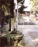 本殿の手前に文字が刻まれた石柱が立っている加良比乃神社の境内の写真