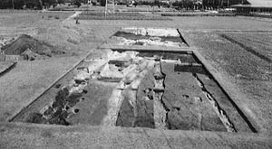 畑の一角に柱などの発掘跡が残る斎宮跡を撮影したモノクロ写真