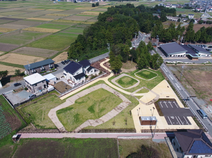 道路沿いに駐車場やトイレが完備された敷地内に3つの古墳が並んでいる坂本古墳公園を上空から撮影した写真