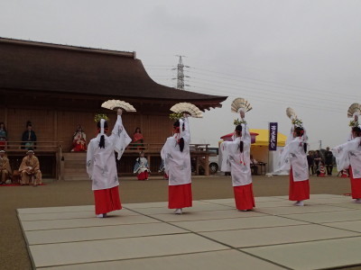正殿の前で5名の女性が白色の着物を着て右手に開いた扇子を持ち踊っているさいくう平安の杜で開催されたイベントの様子の写真