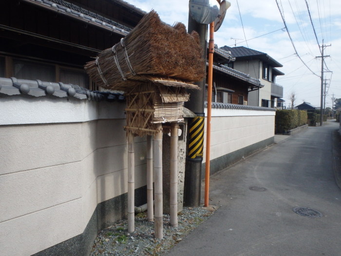 常夜灯と書かれた石碑の手前に建てられた4本の竹の柱の上に藁を乗せて作られた天王さんのお社塔の写真