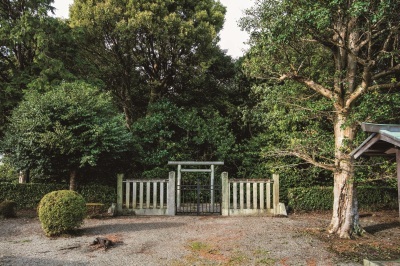 小さな鳥居の奥に樹木に覆われた隆子女王の墓を正面から撮影した写真