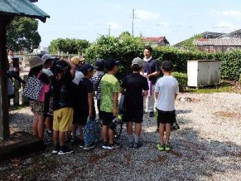 職員の男性の説明を生徒の皆さんが聞いている写真