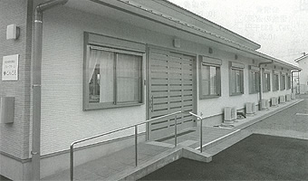 入り口にスロープや手すりが設置されている横長の建物の写真