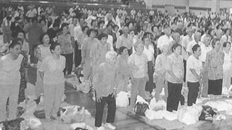 体育館内に整列して立っている、大勢の敬老福祉大会の参加者の写真