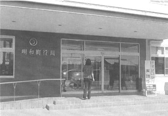 明和町役場庁舎の入り口にたっている来庁者の写真