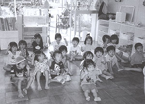 教室の床に座っているみどり保育所の園児たちの写真