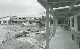 L字型に設計されている建設中のこども園の建物外観の白黒写真