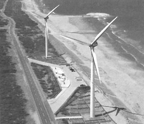 海岸沿いに設置された2基の風力発電設備の写真