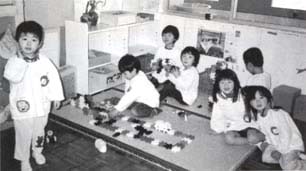 教室内でおもちゃで遊んでいる斎宮幼稚園の園児たちの写真