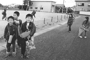 道路を歩いている下校中の子供たちの写真