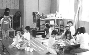 牛乳パックを使って工作をしている放課後児童クラブ室の子供たちの写真