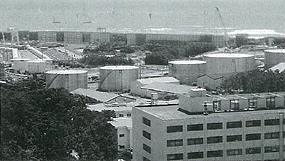 浜岡原子力発電所の奥の建設中の防波堤を高台から撮影した白黒写真