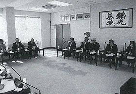 一人ずつ席に座っている議員の方達が話し合っている白黒写真