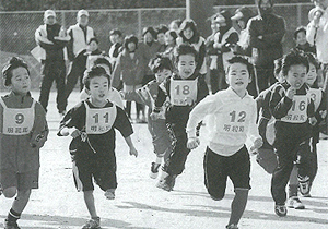ゼッケンをつけた子どもたちが一斉に走り出したマラソン大会の様子の白黒写真