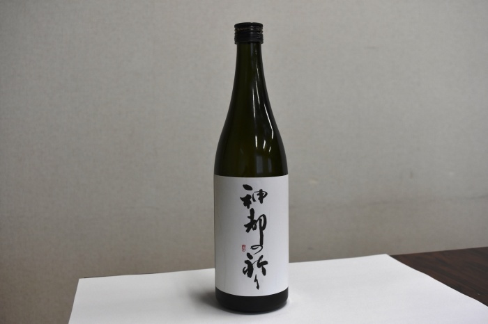 白地に筆で流れるような文字で、「神都の祈り」と書かれたラベルが貼られた日本酒の瓶の写真